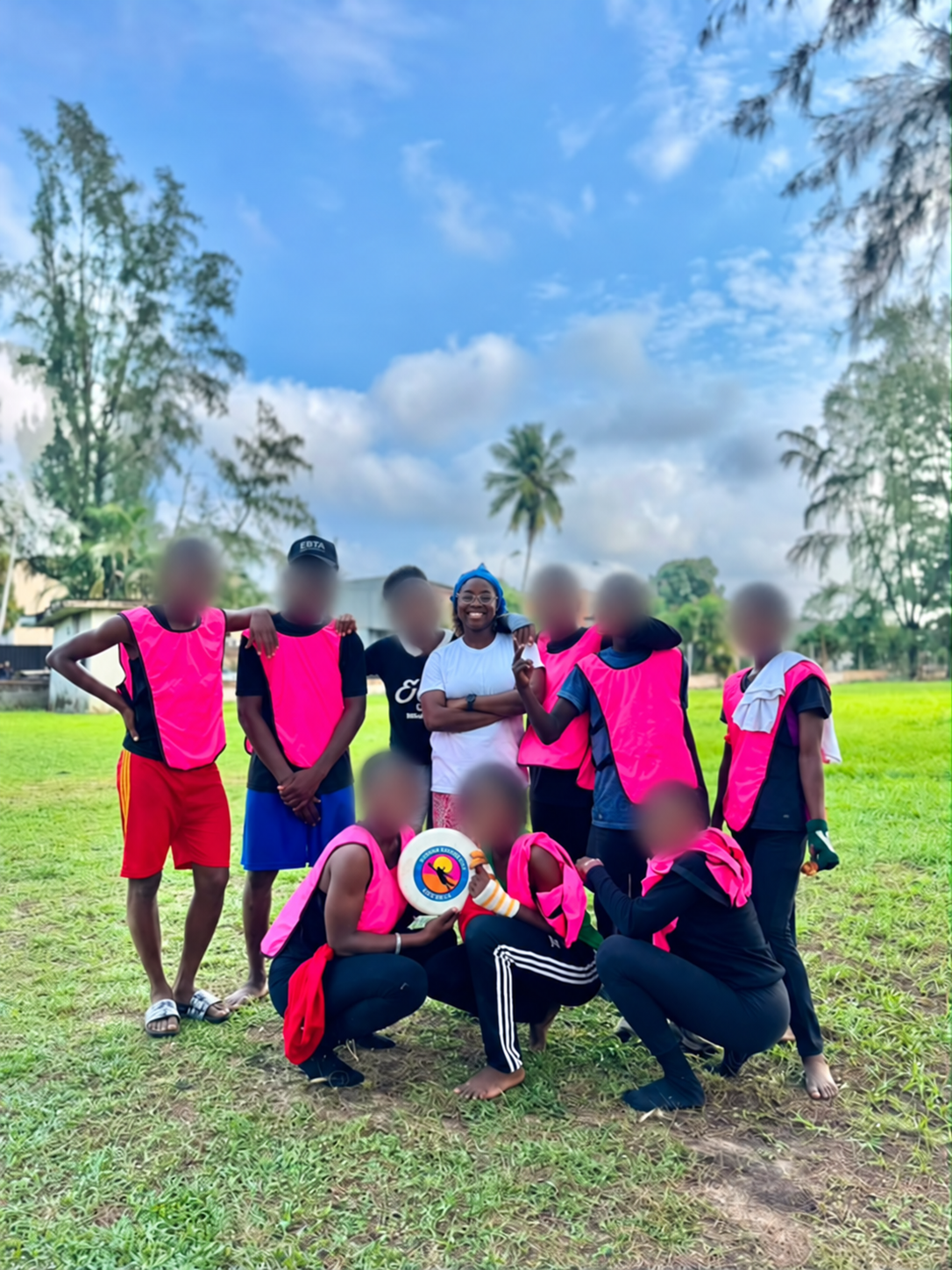 Lauretta with the young people she helps train in sport; all other faces are blurred for privacy